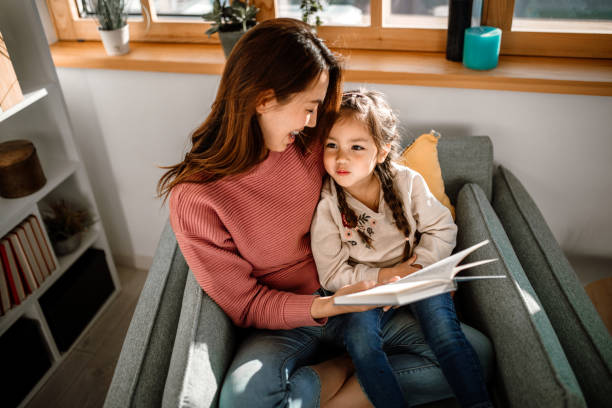 istock Mother and little daughter reading book together 1408770106