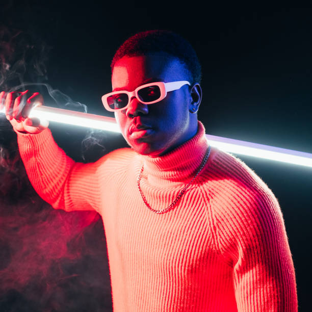 neon night portrait cyberpunk man sci-fi character Neon night portrait. Cyberpunk man. Sci-fi character. Serious confident guy holding LED light futuristic sword in smoke at dark studio background. cosplay photos stock pictures, royalty-free photos & images