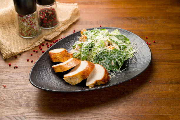 istock Salad caesar with chicken on black plate 1408774285