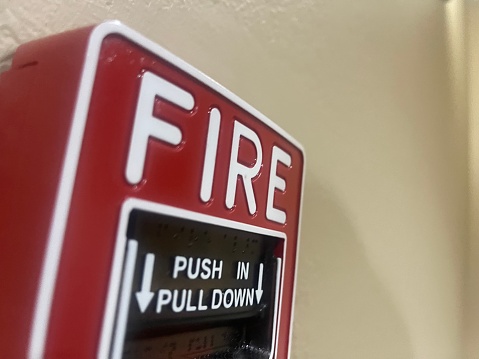 Fire alarm activation equipment box which is installed on the building wall. Close-up and selective focus on the object's part.