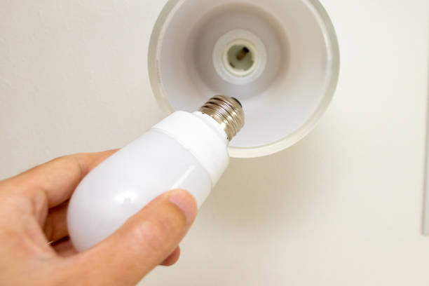 smiling attractive young man, holding the LED bulb in his hand