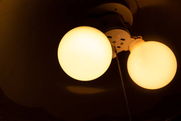 istock Two orange light bulbs that glow in a dark room 1408796264