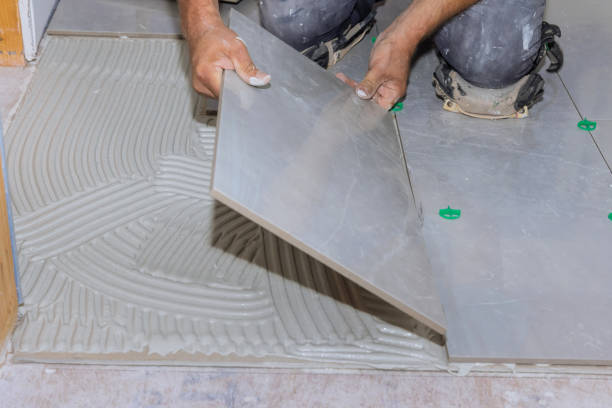 istock Using adhesive to install ceramic floor tiles in a home construction project 1408796927