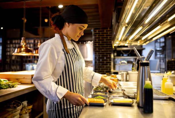 istock Cook working in the kitchen of a restaurant preparing food 1408797950