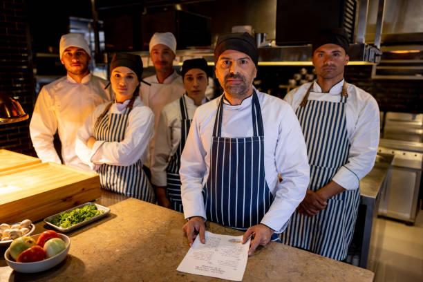 istock Group of chefs and cooks in the kitchen at a restaurant 1408797964