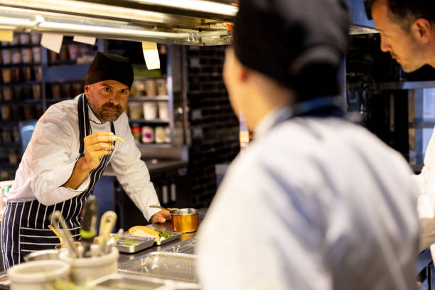 istock Chef training a group of cooks at a restaurant 1408797968