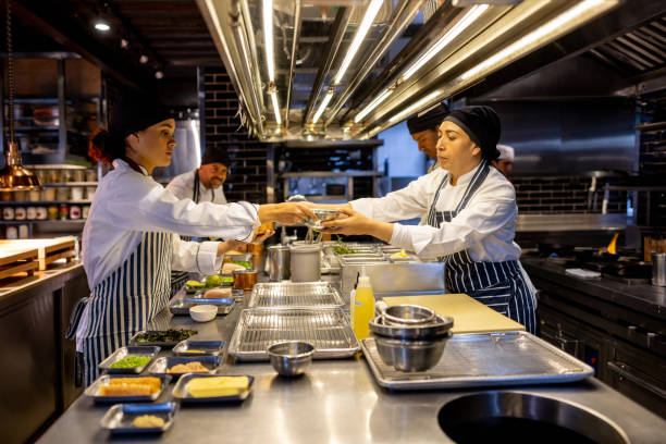 istock Group of cooks preparing food while working at a restaurant 1408797993