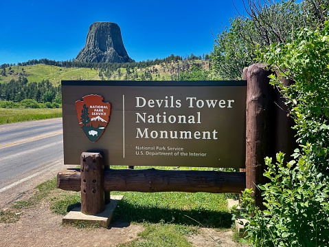 Devils Tower, Wyoming, USA - July 8, 2022: The large geographic icon known as “Devils Tower” looms in the background at the entrance to Devils Tower National Monument in northwest Wyoming.