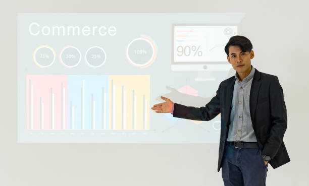 istock Young asian businessman in suit giving presentation with projector screen. White wall with financial report and lecturer. Training staff, meeting, report, business school. 1408807687