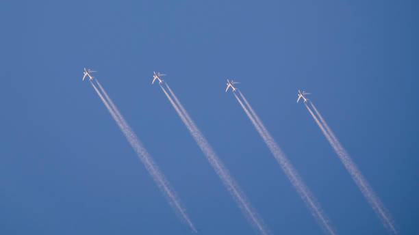 istock Little four planes flying in blue sky with clouds smoke. 1408808585