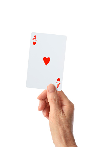 Close-up of hand holding a ace of hearts against white background.