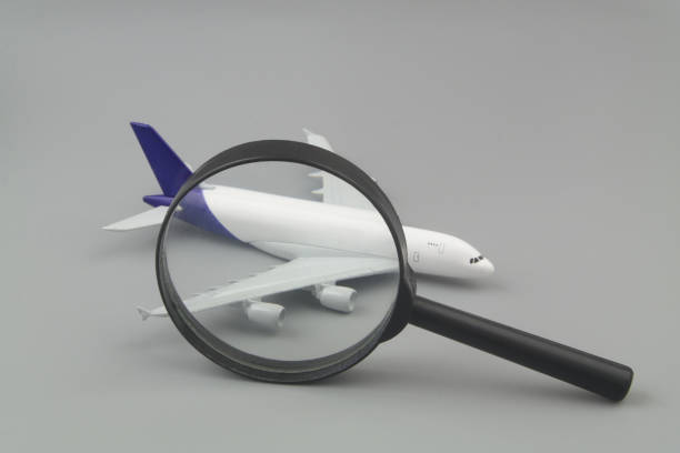 istock Airplane model under magnifying glass and calculator on gray background 1408817512