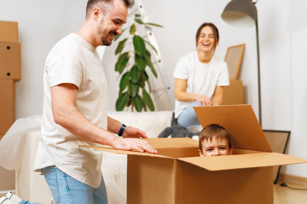 istock Parents and son packing boxes and moving into a new home 1408817547