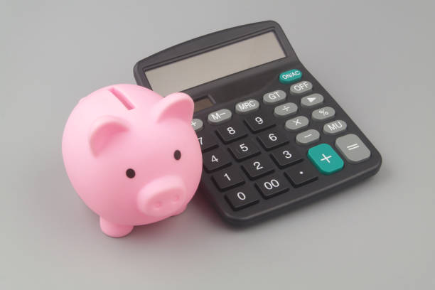 istock Piggy bank and calculator on gray background 1408818088