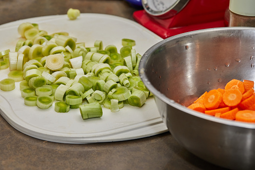 Chopped leeks and carrots on plate for cooking.