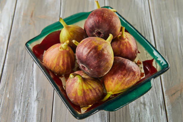 istock Fresh figs In green plate on wooden background 1408818137