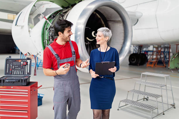 istock Manager and mechanic in airplane hangar 1408818313