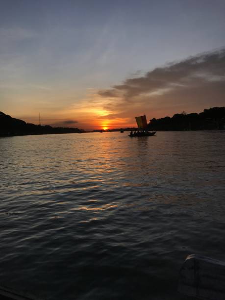 istock Sunset in the river with boat background and red sun 1408818420