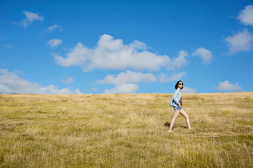 Asian Chinese woman from Hong Kong enjoying a relaxing walk in the countryside under the blue sky during a holiday.