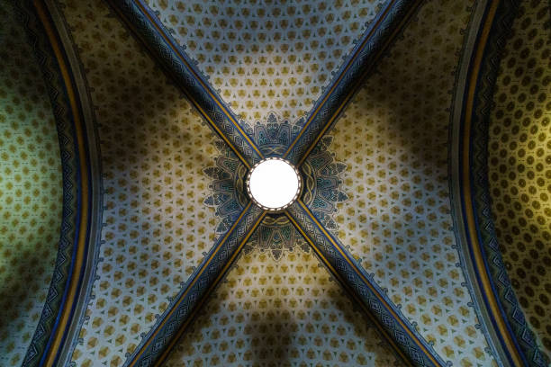 Looking up at the ceiling with beautiful chandelier and decorative engraved ceiling
