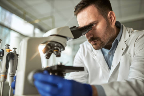 istock Young male scientist working on a microscope in laboratory. 1408826338