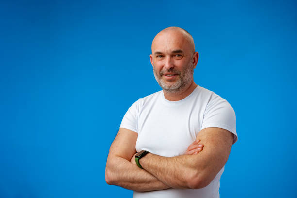 Portrait of a middle-aged man against blue background in studio