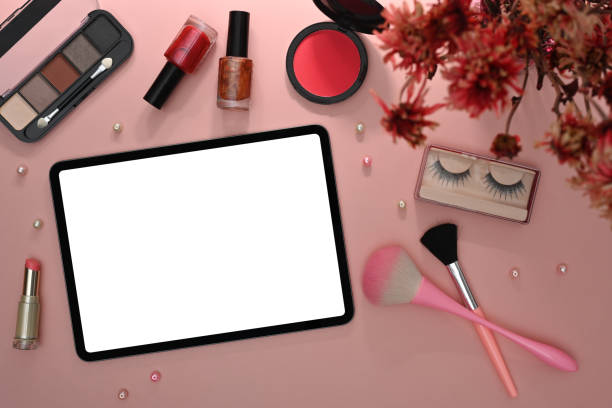 istock Digital tablet, makeup brushes, cosmetics and flowers on pink background. Flat lay, Top view. 1408829271