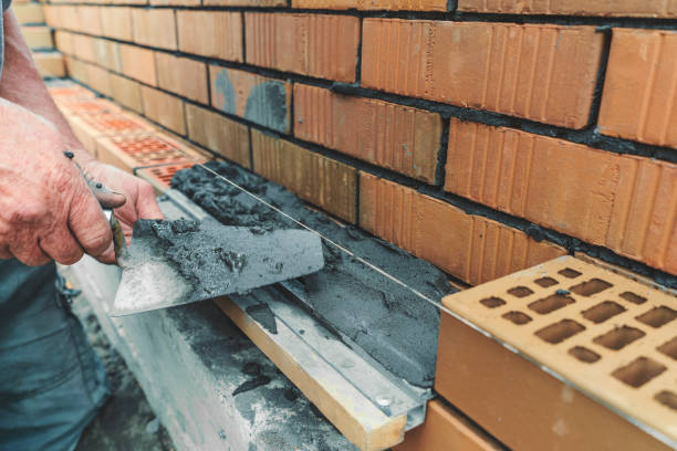 mãos de operário ou pedreiro colocando tijolos de perto. pedreiro trabalha na fila de tijolos. alvenaria em canteiro de obras - mason brick bricklayer installing - fotografias e filmes do acervo