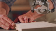 istock Male hands cutting a piece of wood with the scroll saw 1408831590