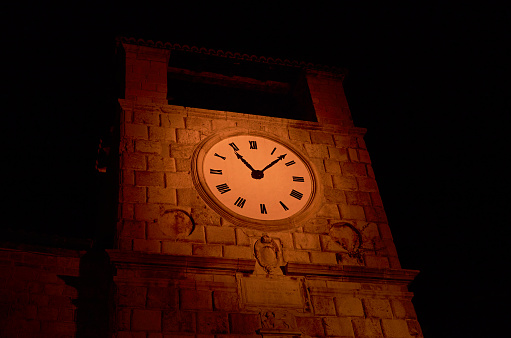 Top of a clock-tower in the night - illuminated