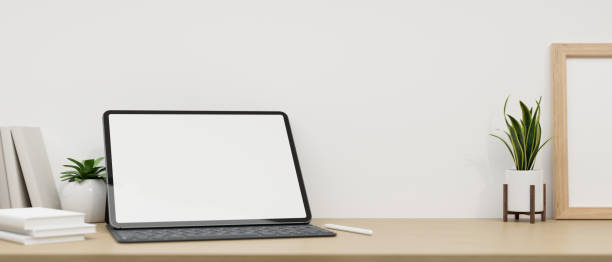 istock Minimal workspace tabletop with tablet mockup and decor plant over white wall. close-up image 1408831817
