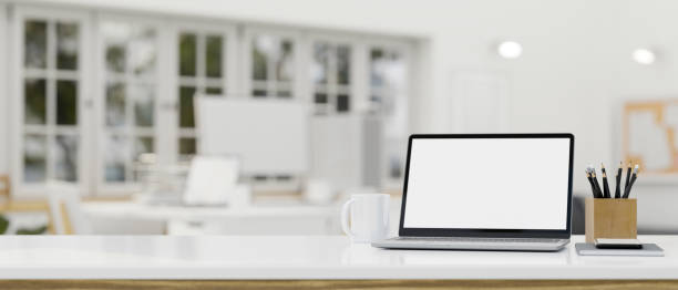istock Notebook laptop mockup and copy space on tabletop over blurred bright office co-working space 1408832653