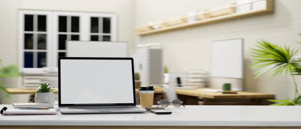 istock Office desk tabletop with laptop mockup and copy space over blurred office background 1408832689