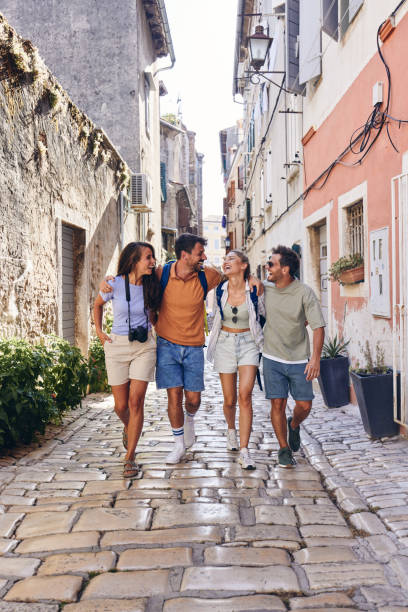 istock Happy tourists talking while walking embraced on the street. 1408837138