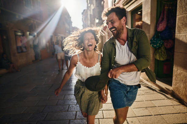 istock Playful couple having fun while running on the street. 1408838869