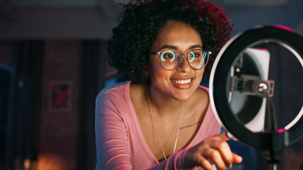 istock Beautiful Young Female Setting Up Studio Lighting and Smartphone to Record a Dancing Routine on Video for Social Media. Stylish Black Girl in Glasses Streaming Her Choreography on Internet from Home. 1408840750