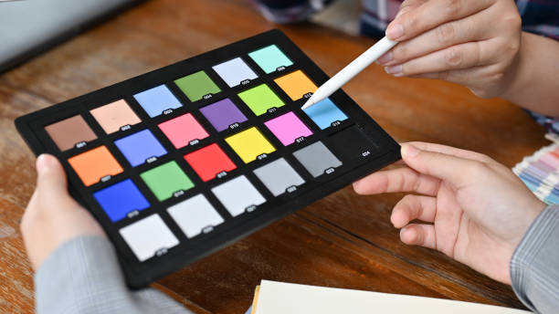 istock A female graphic designer or photo editor holding a colour checker chart. 1408840858