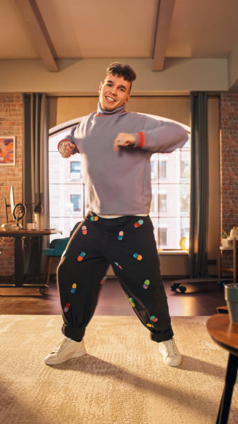 istock Vertical Screen: Handsome Young Man Recording a Dancing Routine on Smartphone Video for Social Media. Stylish Man Streaming His Choreography Masterclass Online on Internet from Home. 1408842282