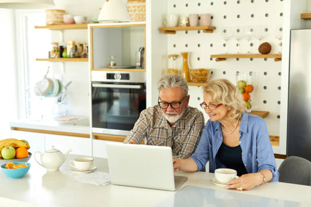 istock Senior couple checking their bills using laptop in the kitchen 1408843168