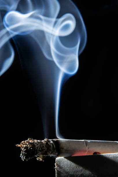 istock Cigarette smoking closeup isolated on balck background. No smoking concept 1408843506