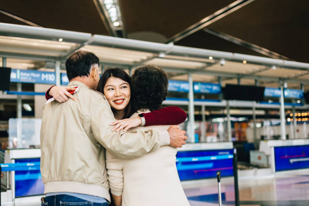 daughter embraces old parents before flying Young girl embracing grand parents at airport before going departure on flight klia airport stock pictures, royalty-free photos & images