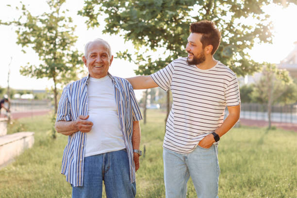 istock Happy senior man walking with son at park 1408845292