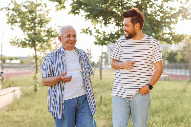 istock Happy senior man walking with son at park 1408845454