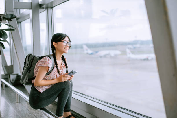 istock Young girl is looking at a plane 1408846622