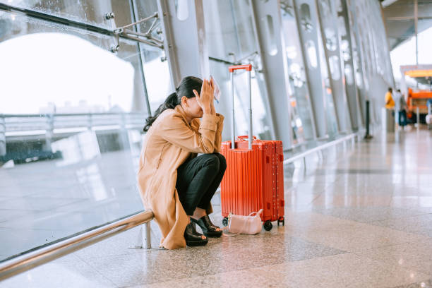 joven asiática molesta y frustrada mientras cancelaba el vuelo en el aeropuerto - cancelación fotografías e imágenes de stock