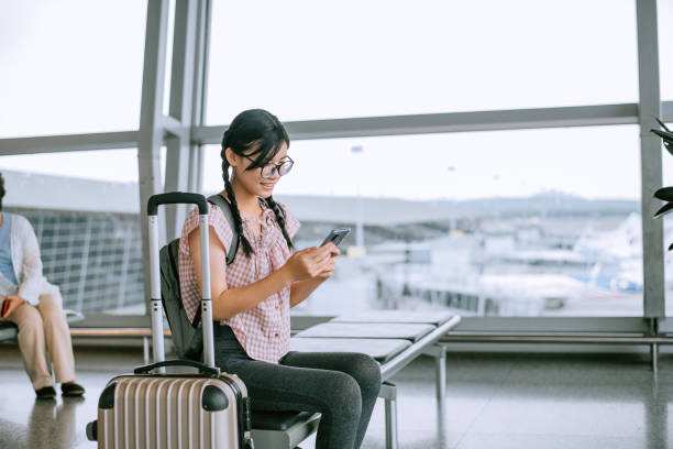 istock Girl Using Phone While Sitting In Waiting Room At Airport 1408846643
