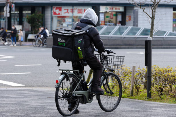 Uber Eats delivery person waits on a bicycle stock photo