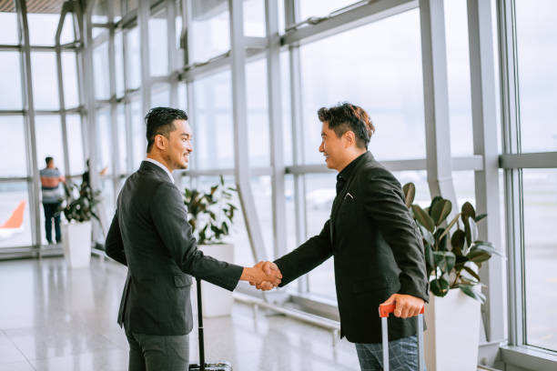 Business people shaking hands at airport stock photo