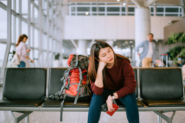 bored woman with backpack in airport waiting room - airport waiting room waiting airport lounge imagens e fotografias de stock