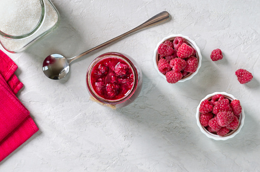 Raspberries with sugar. Berry jam in a jar, fresh raspberries. Top view, copy space